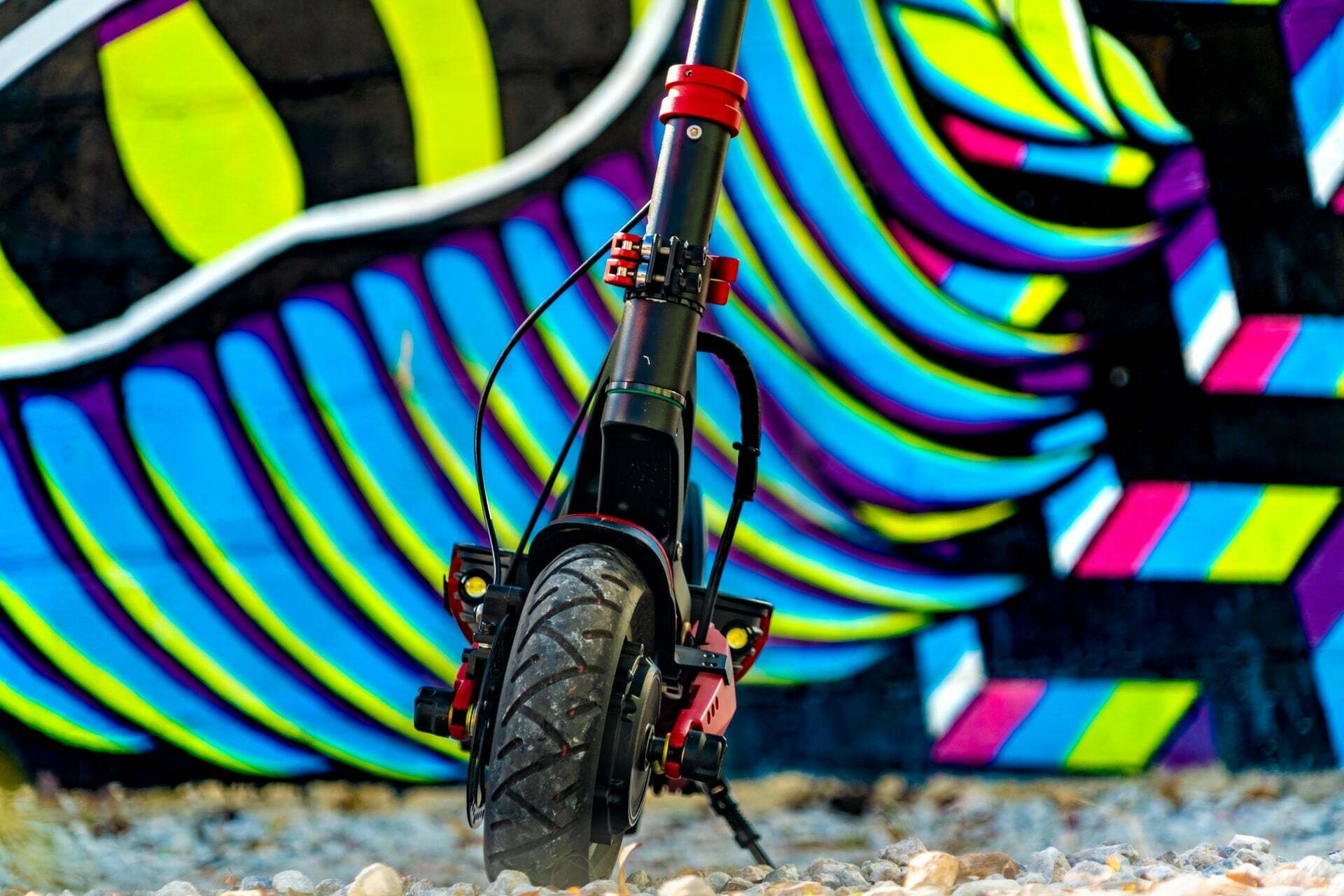 Front view of electric scooter with vibrant wall in the background.