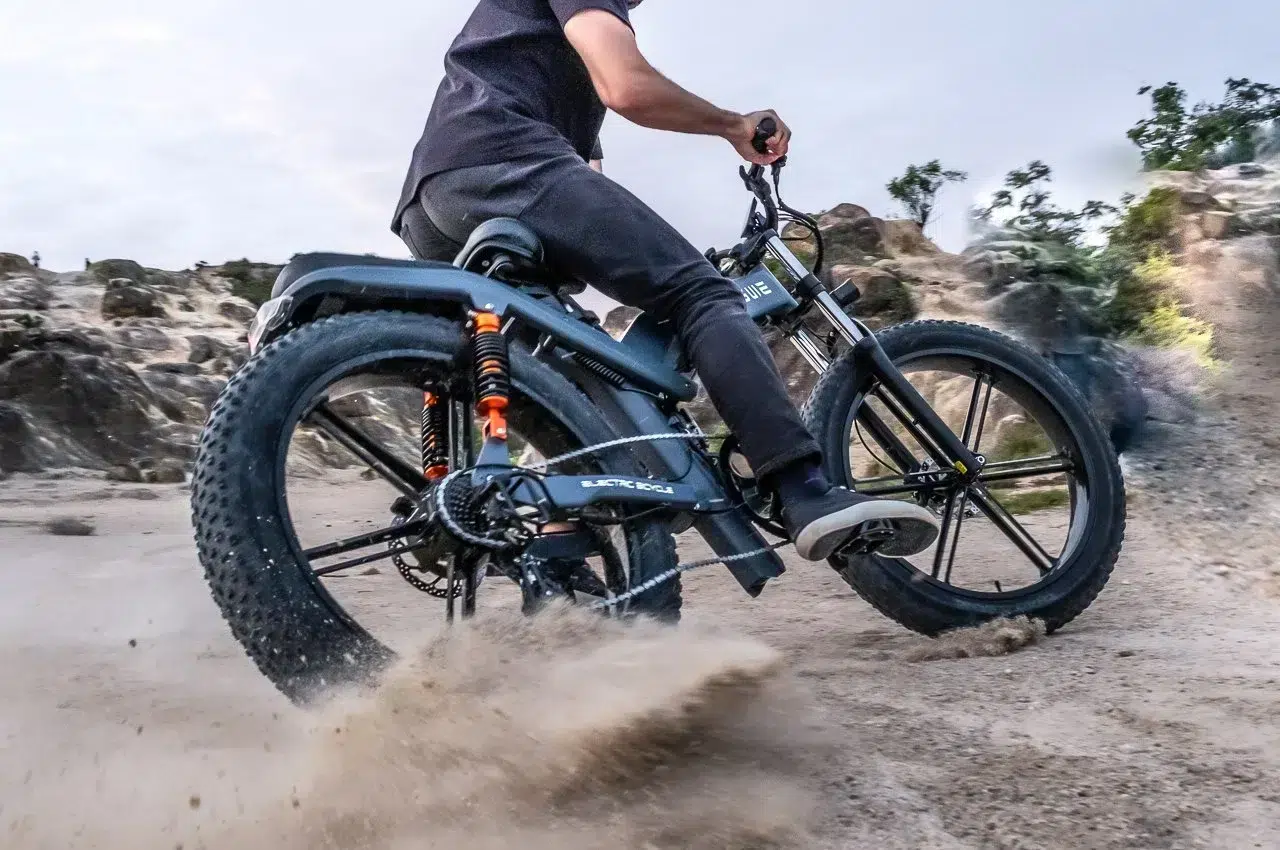 A man riding an all-terrain ENGWE electric bike on a dirt path.